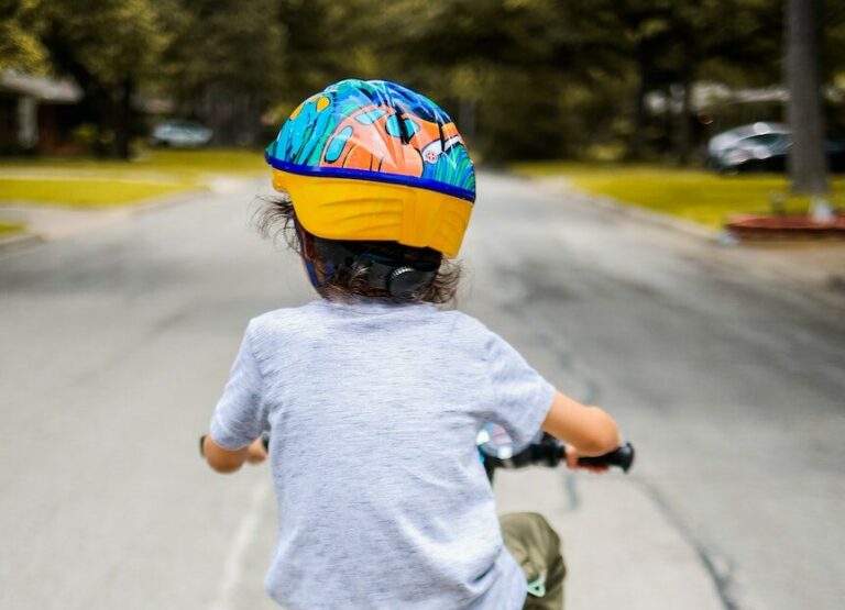Child wearing a helmet and riding a bicycle.